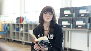 SNACS student with book