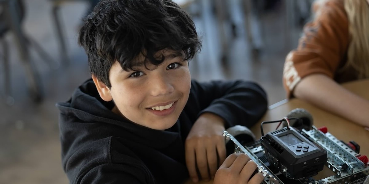 SNACS student smiling with robotics project