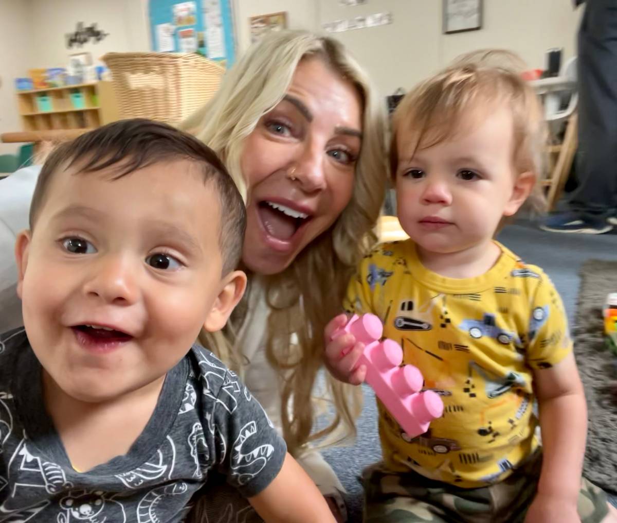 Founder and CEO Dr. Kimberly Regan smiles with 2 SNACS preschool students.